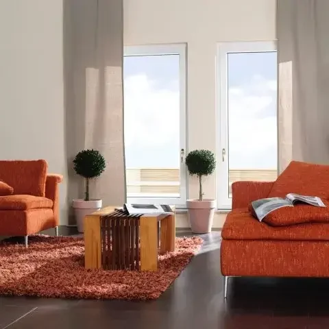 Salón moderno con ventanales de PVC Intelivent de alta eficiencia energética y diseño elegante.