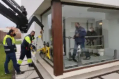 Operarios de Intelivent realizando la instalación profesional de grandes paneles de vidrio en fachada.